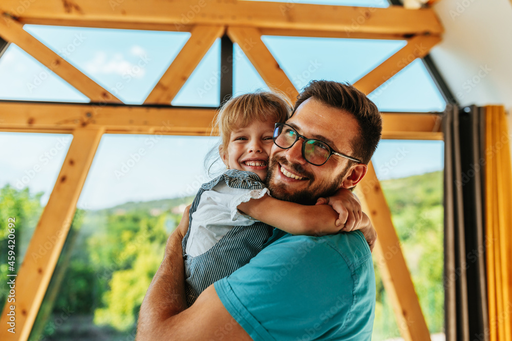 Obraz premium Man hugging shy daughter at home