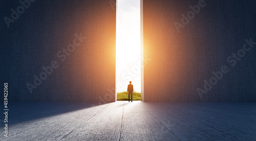 Businessman walking to open gate to a new better green world