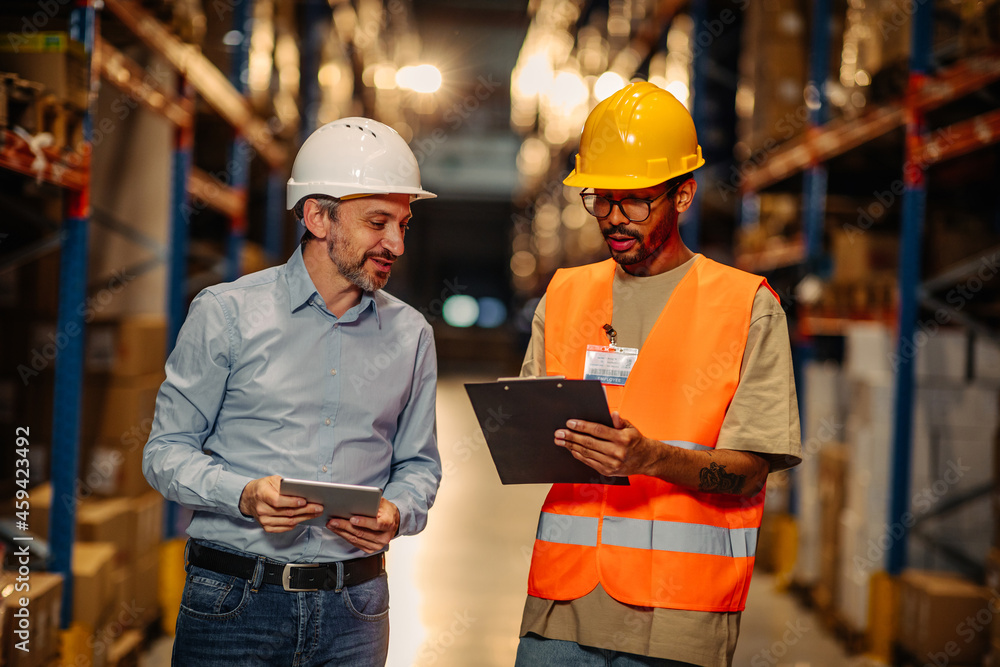 Supervisor and male worker at meeting in warehouse Supervisor and male worker at meeting in warehouse