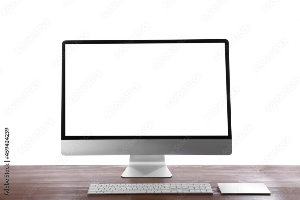 Modern computer with blank monitor screen and peripherals on wooden table against white background Modern computer with blank monitor screen and peripherals on wooden table against white background