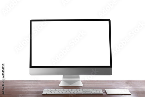 Modern computer with blank monitor screen and peripherals on wooden table against white background