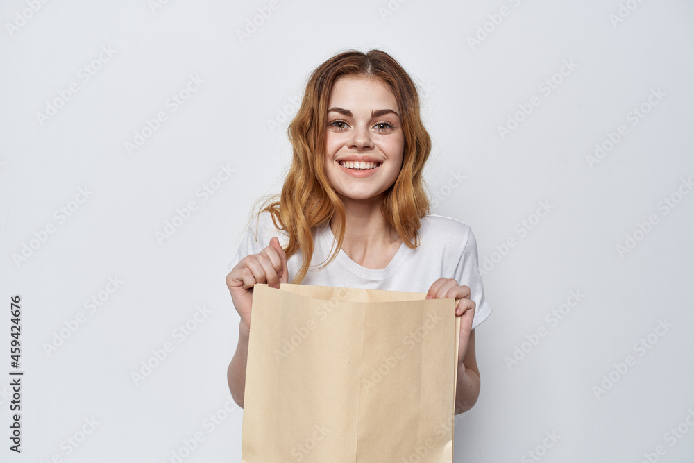 pretty woman in white t-shirt with shopping bag in her hands pretty woman in white t-shirt with shopping bag in her hands