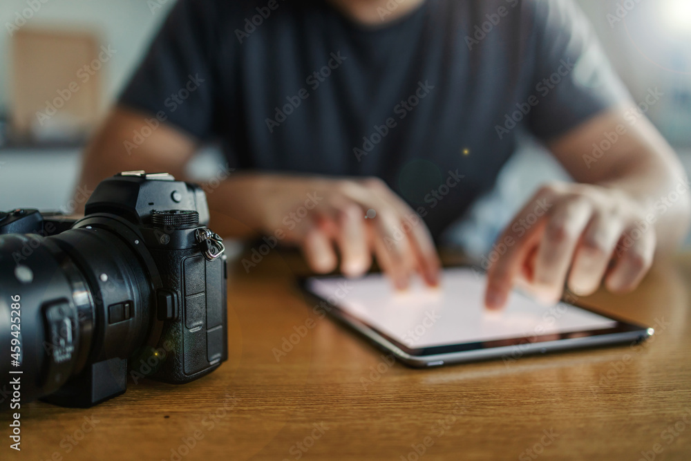 Office table of the photographer. Tablet with blank empty mockup space for ads massage. Photo camera on the side of a hard-working man. Freelancer work, love my job, creative chaos Office table of the photographer. Tablet with blank empty mockup space for ads massage. Photo camera on the side of a hard-working man. Freelancer work, love my job, creative chaos