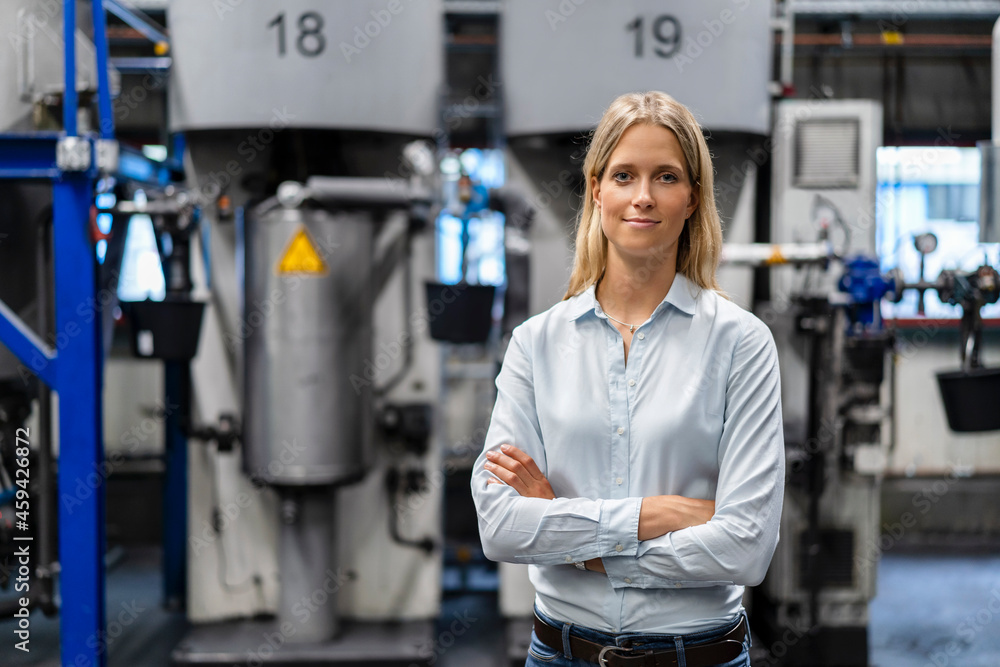 Female professional standing with arms crossed at industry Female professional standing with arms crossed at industry
