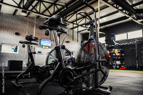 Exercise bicycle, no people. Focus on black indoor bikes in an empty gym with no people. Spinning room inside of modern gym space. Sport, fitness, stay in good psychical shape