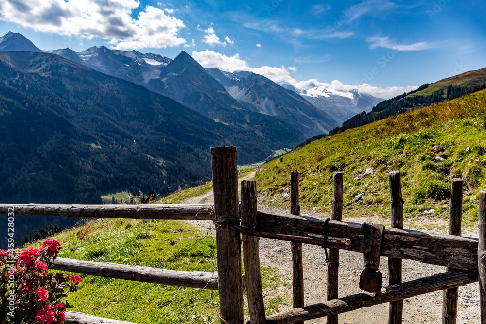 Mountain pub fence with bell and view on Alps