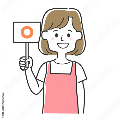 丸の札を持っているエプロンを着た主婦