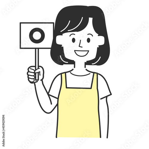 丸の札を持っているエプロンを着た主婦