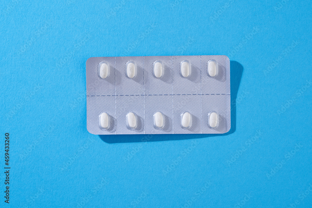 strip of pills on blue background strip of pills on blue background
