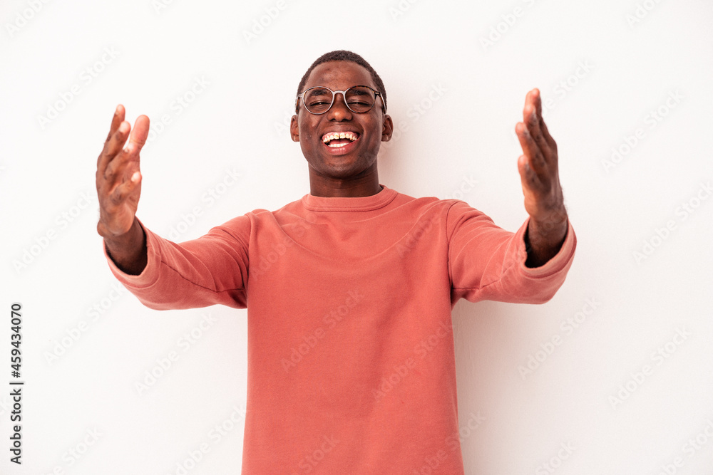 Naklejka premium Young African American man isolated on white background celebrating a victory or success, he is surprised and shocked.