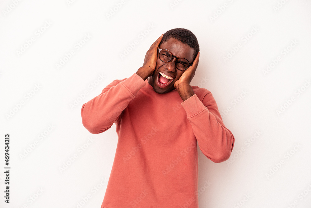 Young African American man isolated on white background covering ears with hands trying not to hear too loud sound. Young African American man isolated on white background covering ears with hands trying not to hear too loud sound.