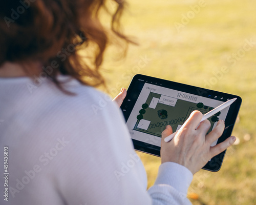woman using digital tablet, person draws graphic landscape pictures on a tablet