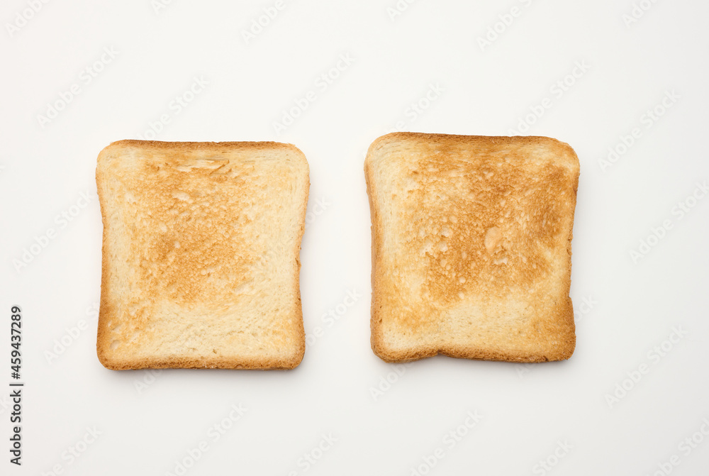 square slices of bread made from white wheat flour toasted in toaster, top view square slices of bread made from white wheat flour toasted in toaster, top view