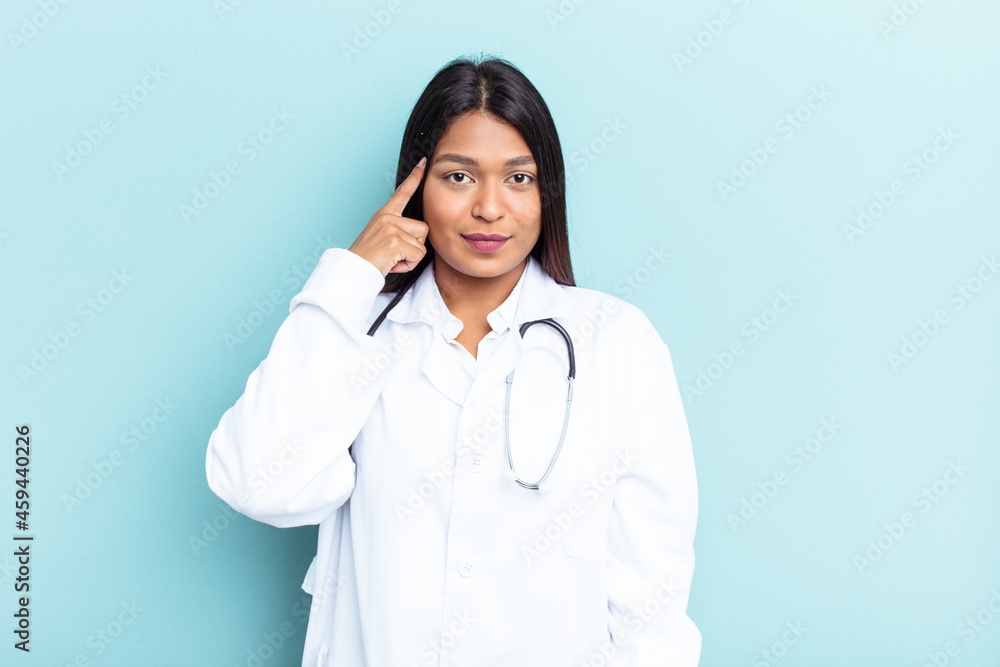 Young doctor Venezuelan woman isolated on blue background pointing temple with finger, thinking, focused on a task. Young doctor Venezuelan woman isolated on blue background pointing temple with finger, thinking, focused on a task.
