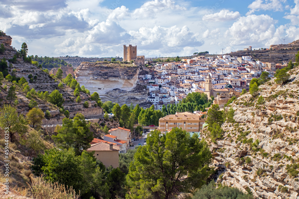 View on Alcala del Jucar, Castilia la Mancha, Spain, its castle towering above the white village. in the gorges of the Jucar river