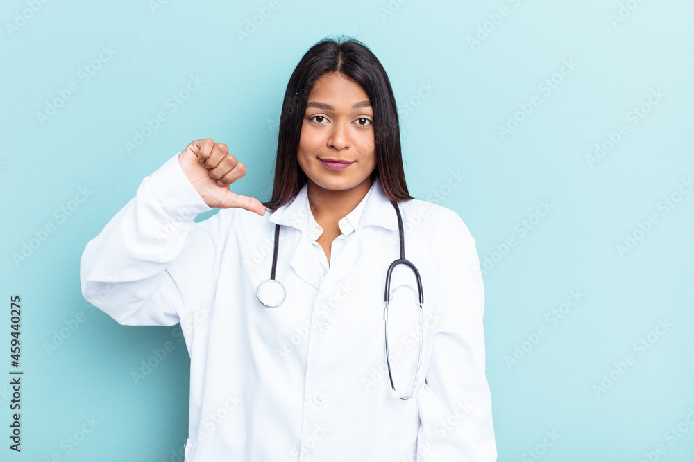 Young doctor Venezuelan woman isolated on blue background showing a dislike gesture, thumbs down. Disagreement concept.