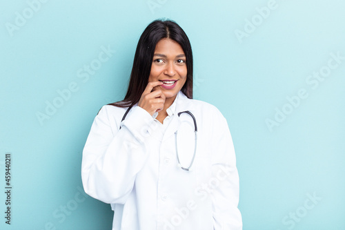Young doctor Venezuelan woman isolated on blue background relaxed thinking about something looking at a copy space.