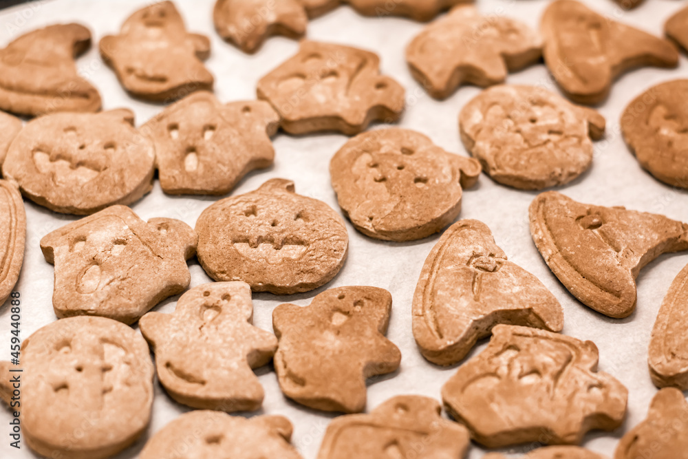 Preparing to celebrate halloween and preparing a treat. Halloween baked gingerbread cookies on a baking sheet. Lifestyle Preparing to celebrate halloween and preparing a treat. Halloween baked gingerbread cookies on a baking sheet. Lifestyle