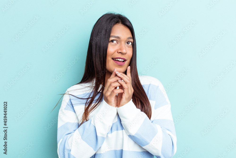 Young Venezuelan woman isolated on blue background making up plan in mind, setting up an idea. Young Venezuelan woman isolated on blue background making up plan in mind, setting up an idea.