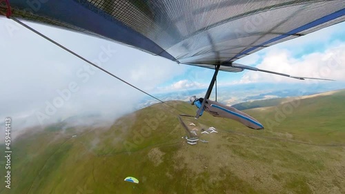 Extreme sports. Hang glider flies high on the mountain ridge