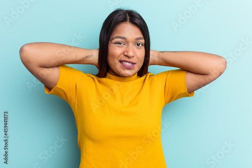 Young Venezuelan woman isolated on blue background touching back of head  thinking and making a choice.