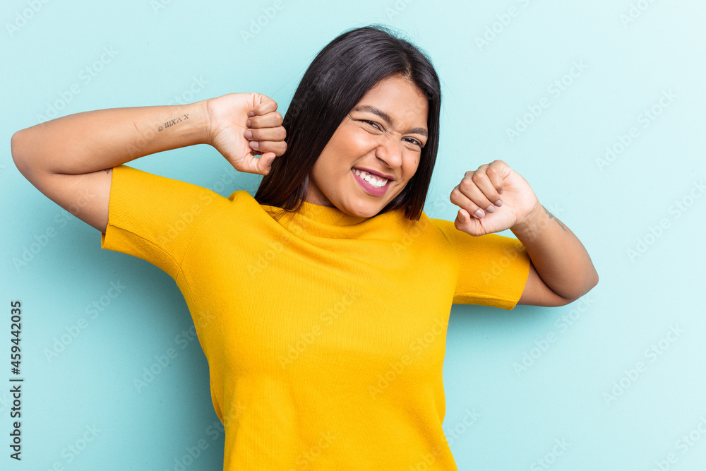 Young Venezuelan woman isolated on blue background stretching arms, relaxed position. Young Venezuelan woman isolated on blue background stretching arms, relaxed position.