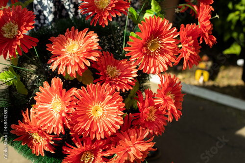 Artificial flowers. Flowers on the monument.