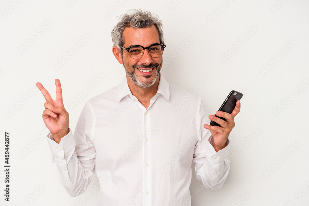 Middle age caucasian business man holding a mobile phone isolated on white background joyful and carefree showing a peace symbol with fingers. Middle age caucasian business man holding a mobile phone isolated on white background joyful and carefree showing a peace symbol with fingers.