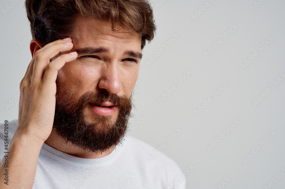 man in a white t-shirt headache migraine problems light background man in a white t-shirt headache migraine problems light background