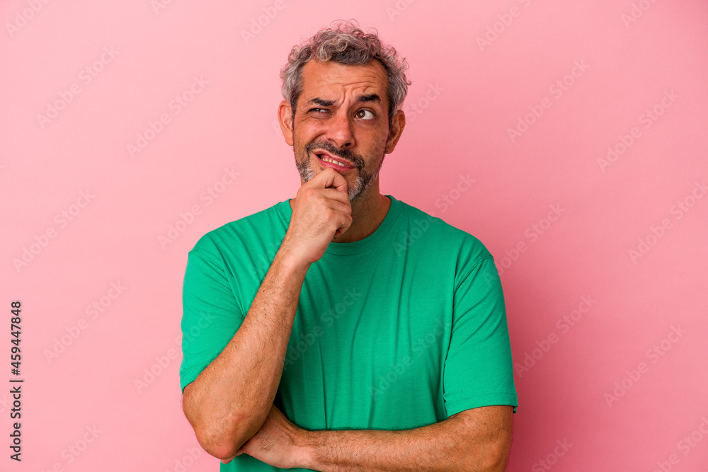 Middle age caucasian man isolated on pink background looking sideways with doubtful and skeptical expression. Middle age caucasian man isolated on pink background looking sideways with doubtful and skeptical expression.
