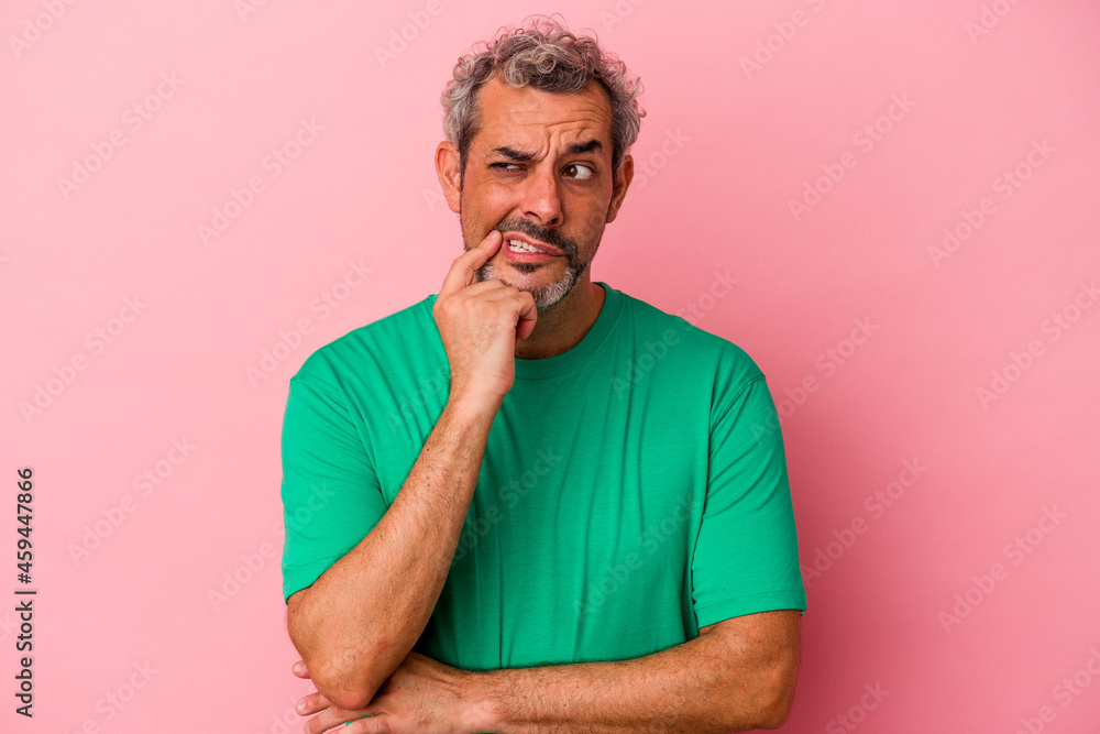 Middle age caucasian man isolated on pink background looking sideways with doubtful and skeptical expression. Middle age caucasian man isolated on pink background looking sideways with doubtful and skeptical expression.