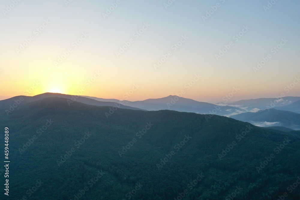 Peaks of the Carpathian Mountains at sunset. Sunset in the mountains, top view. Forest and mountains from a bird's eye view. Mountain range and valley. Peaks of the Carpathian Mountains at sunset. Sunset in the mountains, top view. Forest and mountains from a bird's eye view. Mountain range and valley.
