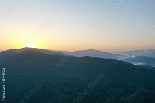 Peaks of the Carpathian Mountains at sunset. Sunset in the mountains  top view. Forest and mountains from a bird s eye view. Mountain range and valley.