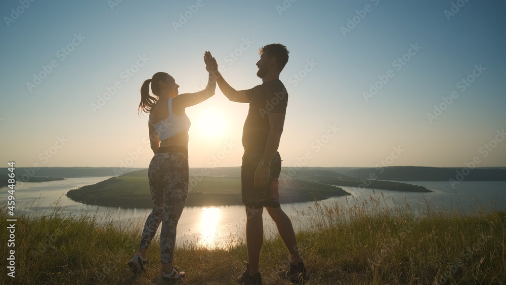 The happy man and woman standing on a mountain top on scenic river background