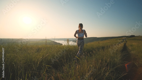 The sportive woman jogging on a scenic background