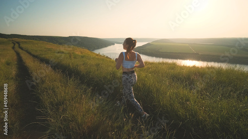 The sportive woman jogging on a scenic background