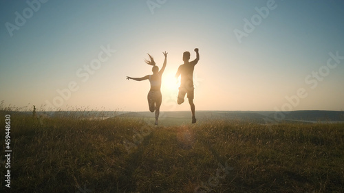 The happy man and woman jumping on a mountain top