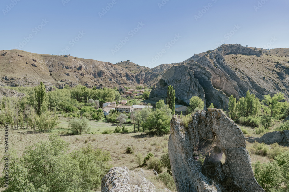 view of village between mountains with rocks in the foreground. In the town of Santamera in Guadalajara in Spain