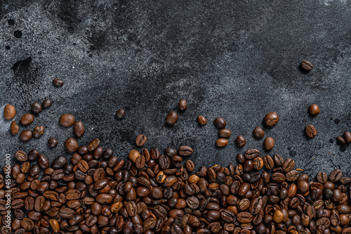Roasted coffee beans on rustic table. Black background. Top view. Copy space