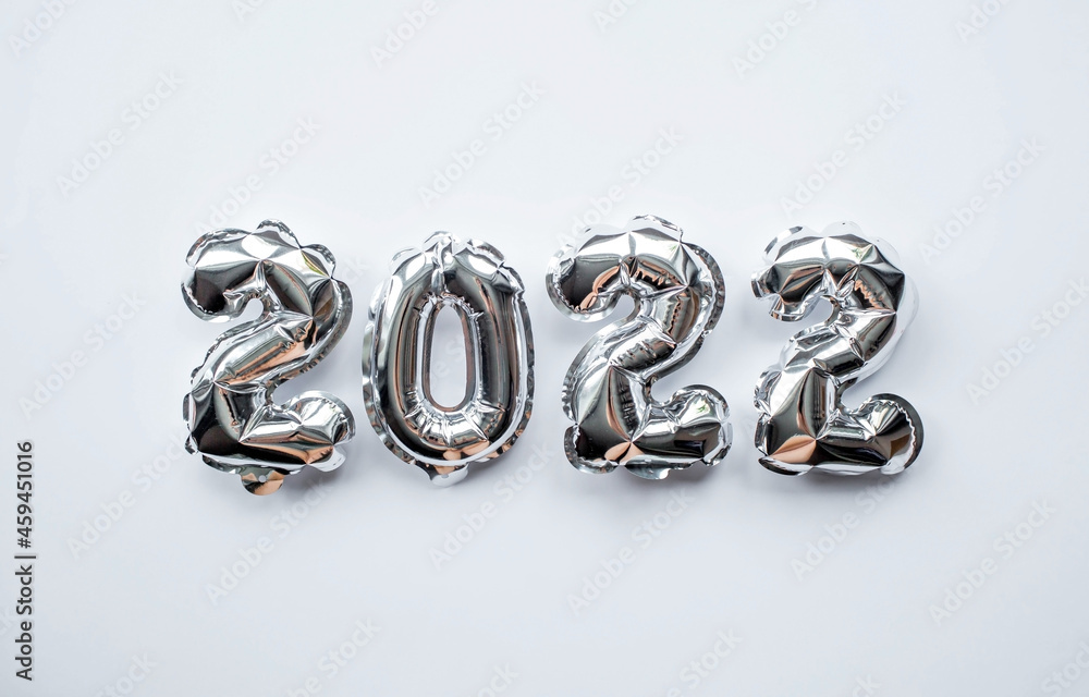 Banner. Happy New Year. Silver foil balloons with number 2022 on an isolated white background. Flat lay. Banner. Happy New Year. Silver foil balloons with number 2022 on an isolated white background. Flat lay.