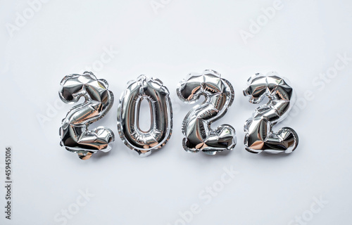 Banner. Happy New Year. Silver foil balloons with number 2022 on an isolated white background. Flat lay. 