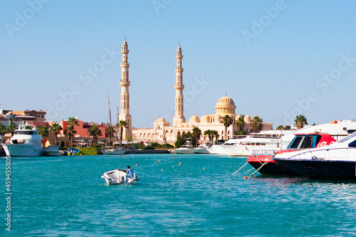 Bild auf Leinwand HURGHADA, EGYPT - September 22, 2021 : Mosque El Mina Masjid and the marina with the ships in Hurghada in sunny day, view from the sea