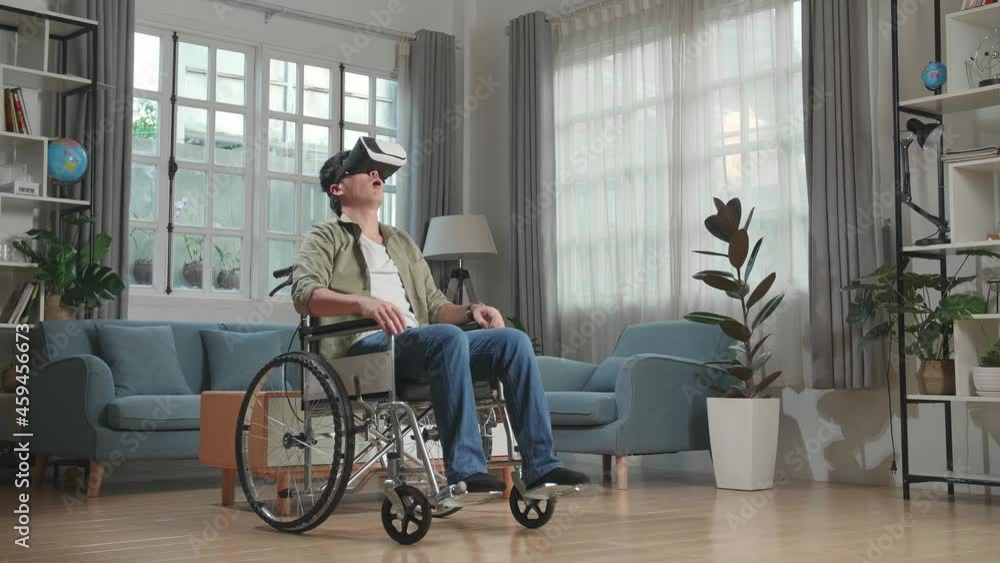 Asian Man Sitting In A Wheelchair While Wearing Virtual Reality Goggles At Home
Asian Man Sitting In A Wheelchair While Wearing Virtual Reality Goggles At Home