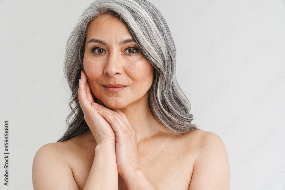 Foto de Mature shirtless woman with grey hair posing and looking at