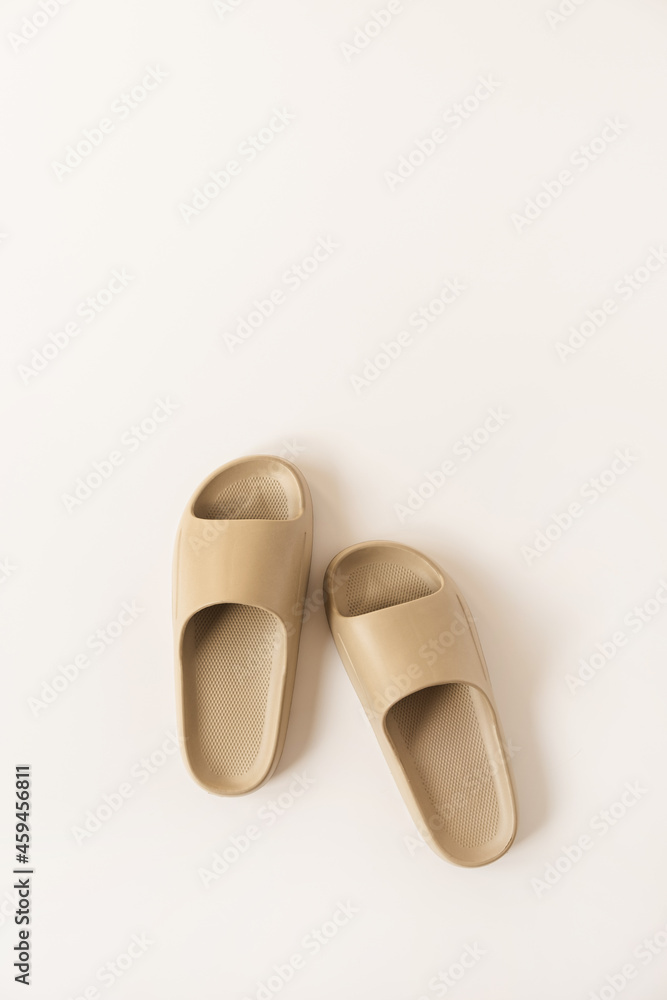 Neutral beige color summer slippers isolated on white background. Flat lay, top view minimalist fashion concept Neutral beige color summer slippers isolated on white background. Flat lay, top view minimalist fashion concept