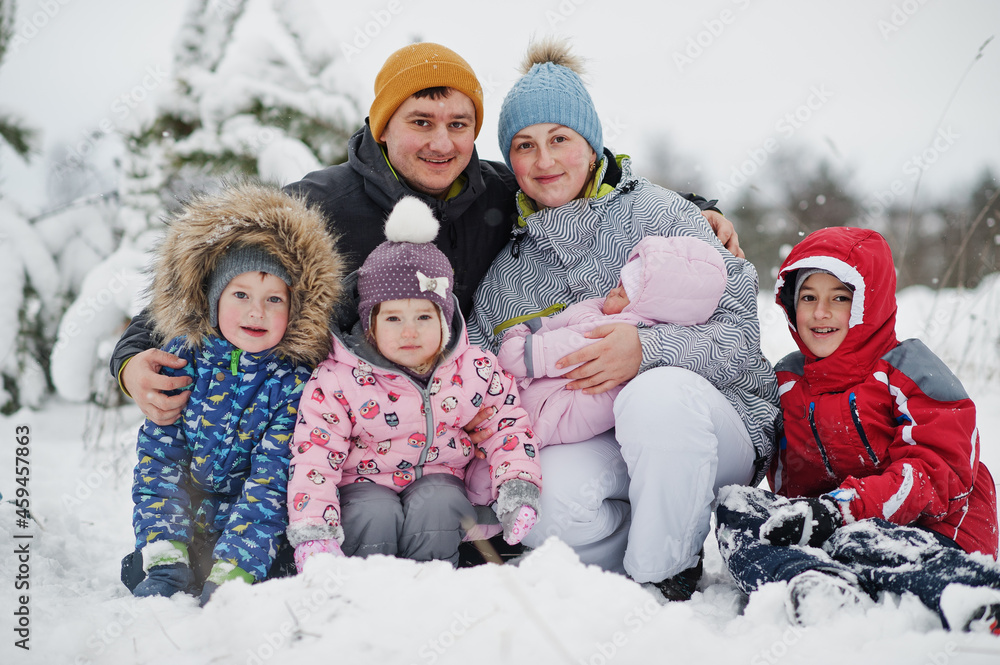Large family of four kids portrait in fairy winter day with snow and snowfall.