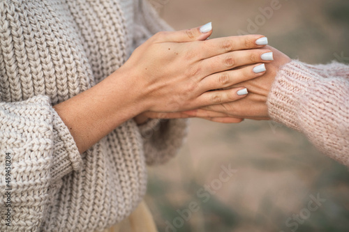 The girls are frozen for walks and warming their hands. A friend warms her hands. Close-up of the hands of two girls. The girl blows warm air on her hands to keep warm © Надин Стокер