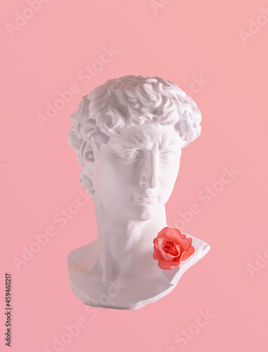 Obraz na plátně Plaster male head and artificial rose, creative composition against pastel pink background