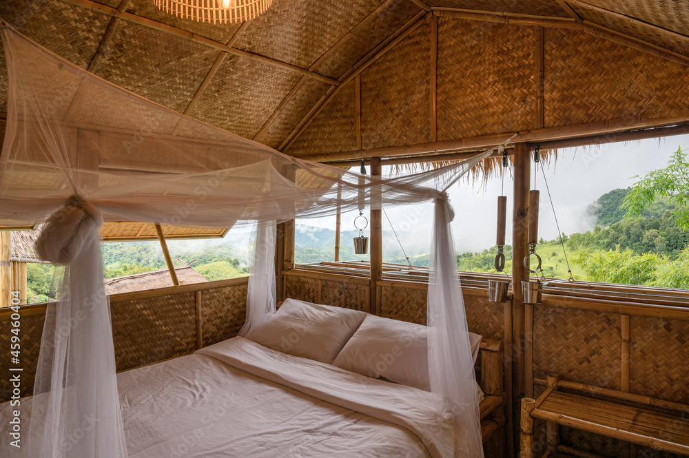 Inside the bedroom that made of wooden thatched with mosquito net among the mountain Inside the bedroom that made of wooden thatched with mosquito net among the mountain