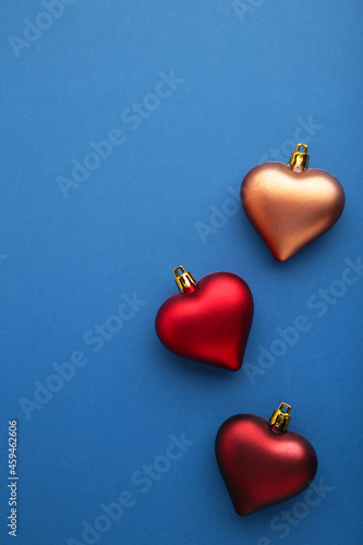 Christmas background. Red toys heart on blue background. Greeting card. New year concept